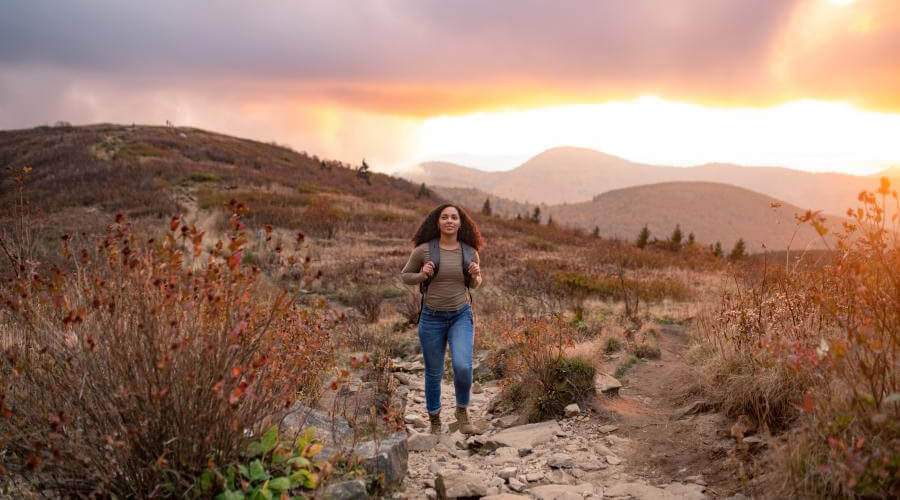Hiker on top of Black Balsam during sunset with fall colors